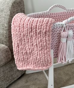 Chunky finger knit blanket in pink on a pink crochet moses basket