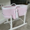 pink and white crochet moses basket on a white rocking stand